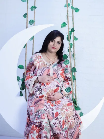 A classic solo portrait on the moon swing. This prop is one of our most requested and provides a whimsical, celestial theme for your maternity shoot.