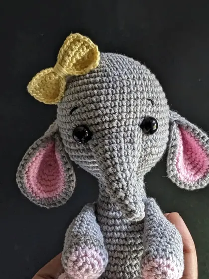 A close-up portrait of the elephant, focusing on her face and bow.