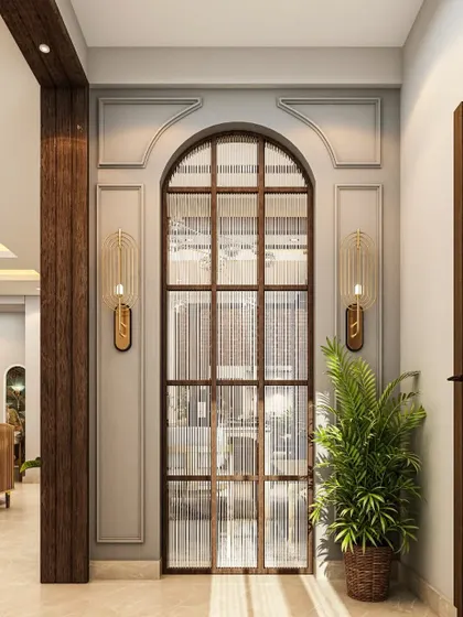A grand entrance featuring an arched doorway with fluted glass, creating a sense of arrival. The design uses classic wall molding and modern sconces to blend traditional and contemporary styles.
