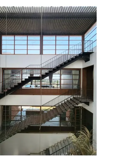 The central stairwell of the Ishtika house, with light filtering down from above. The open design creates a sense of vertical connection through the different levels of the home.