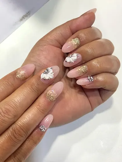 In my advanced nail art classes, I demonstrate the difference between various techniques. Here, you can see a comparison between gel and acrylic extensions, both featuring intricate 3D floral art and glitter accents, to help students understand the unique finish of each method.