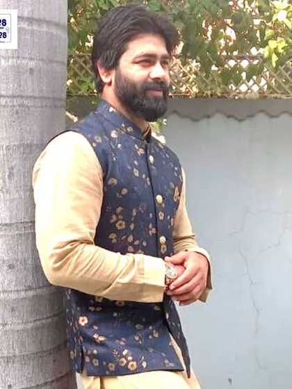 This client is wearing a custom-stitched Nehru jacket with a floral print over a beige kurta. It's a great choice for a Haldi or Mehendi function.