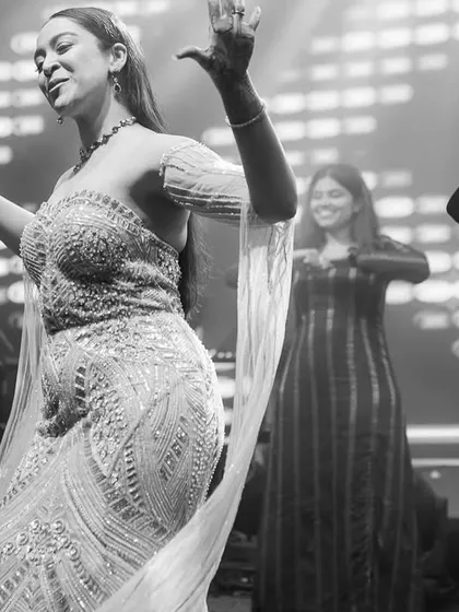 A black and white photo capturing the elegance and joy of a ladies' group performance. The shared smiles show the bond between the performers.