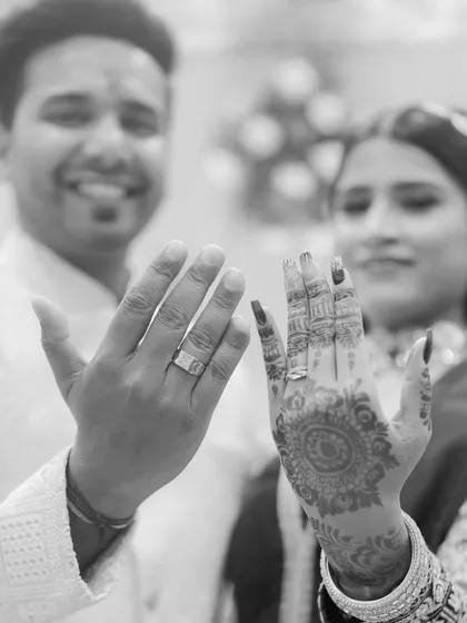A happy, black and white shot of the couple showing off their new rings. This image captures the excitement and significance of the moment in a timeless style.
