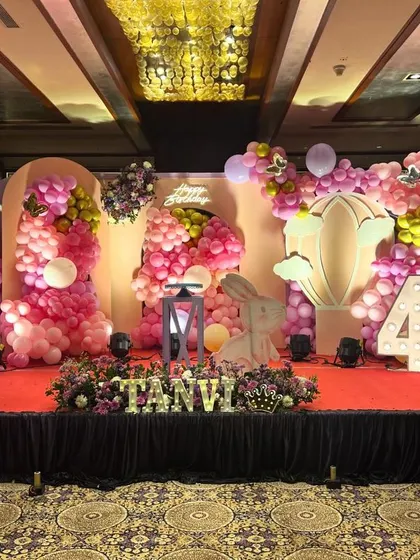 A wide shot of the stunning butterfly and bunny themed stage, showing the full scale of the balloon arrangements and custom backdrops.