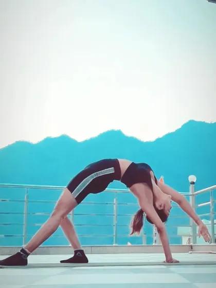 A variation of Chakrasana (Wheel Pose) against a mountain backdrop. This deep backbend is a powerful heart-opener, building strength and flexibility in the spine.