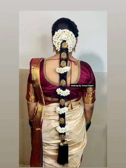 A beautiful Poola Jada hairstyle, featuring sections of fresh jasmine separated by traditional gold hair jewelry. This is a very popular and classic choice for South Indian brides.
