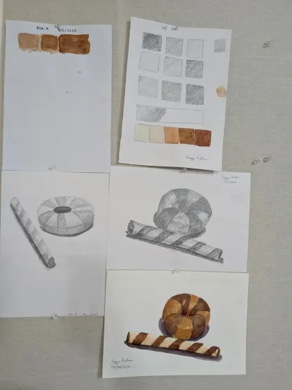 More examples of our foundational exercises. Students practice shading with pencils and creating color gradients with watercolors before applying these skills to drawing objects like donuts and wafer sticks.