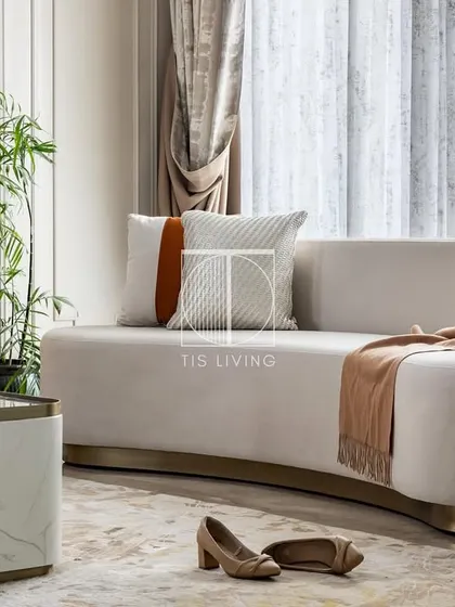 A closer look at the sculpted, curved sofa we designed for this Noida home. The deep seating and soft silhouette are made for relaxation, while the brass base adds a touch of glamour.