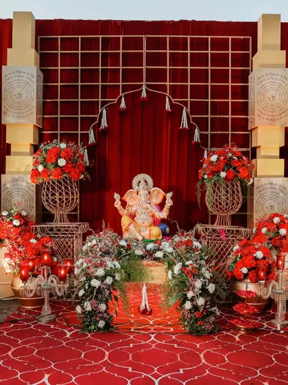A divine start to the celebrations. This Ganesha setup, surrounded by red and white flowers, brings blessings and a touch of traditional elegance to the wedding entrance.
