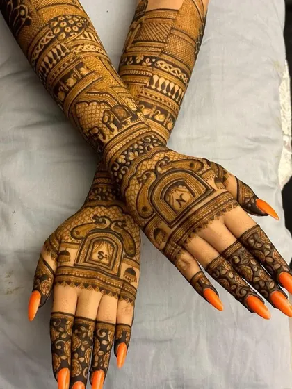 This full-arm design is packed with detail, including bands of elephants, palace windows, and personalized initials of the couple hidden inside jharokha frames.