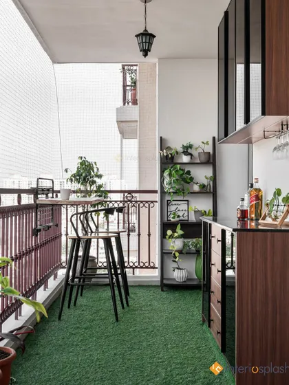This balcony features a built-in bar unit, a high-top table, and shelves for plants. The artificial grass flooring makes it feel like a small private garden.
