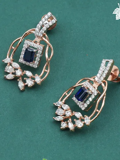 A close-up of the Sapphire Dream earrings. Each earring is a mirror of the pendant's design, capturing the deep blue of the sapphire and the brilliance of the surrounding diamonds.