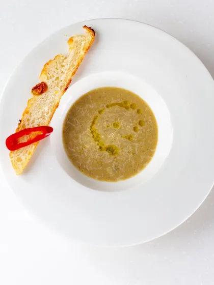 Another take on a hearty, comforting soup, garnished with a drizzle of olive oil and fresh chili.