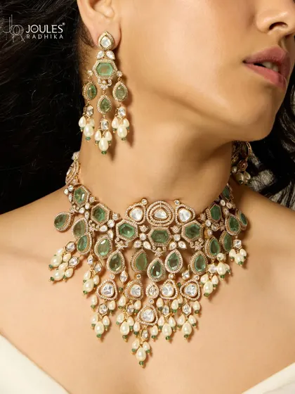 A detailed shot of the cascading emerald and polki necklace, highlighting the movement and sparkle of the piece.