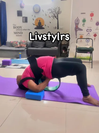 A client uses a yoga wheel and strap for a supported backbend, a fantastic way to safely increase flexibility in the spine and open the heart center.