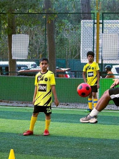 A coach demonstrates a skill to a player. I believe in showing, not just telling, to help players learn effectively.