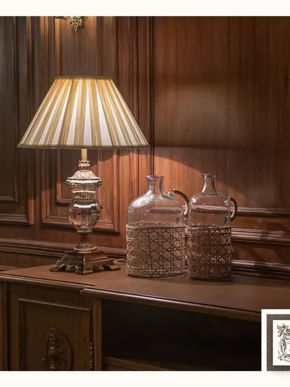 This transparent crystal table lamp is designed to create a luxurious effect. Placed on a dark wood console, its ability to reflect and refract light adds a dazzling touch to the room's ambiance.