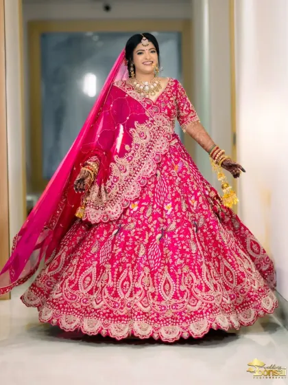 A full-length portrait of the bride in her vibrant pink lehenga, looking absolutely stunning.