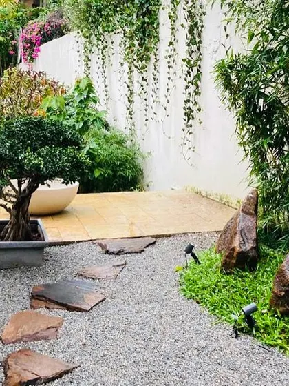 This tranquil corner features a Japanese-inspired garden design. We used gravel, natural stepping stones, carefully placed rocks, and a bonsai tree to craft a space for quiet contemplation.