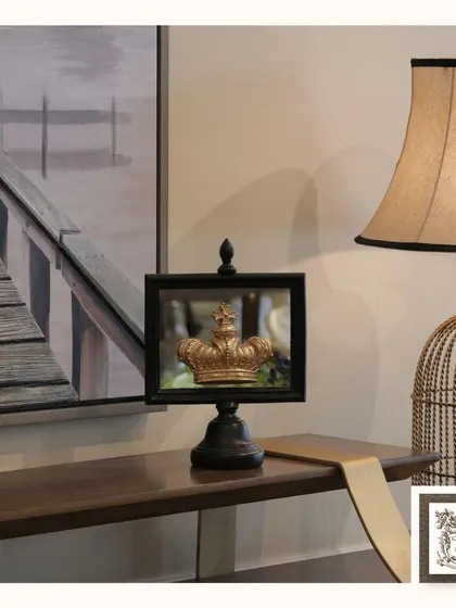 This "Crowning Glory" mirror, with its black frame and gold crown accent, adds a touch of regal charm to a console table. It's a playful yet sophisticated piece that makes a statement.