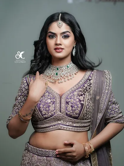 A royal North Indian bridal look. The heavily embroidered lehenga and diamond jewelry are captured with dramatic studio lighting to create a glamorous and powerful portrait.