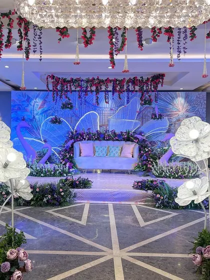The 'Illuminated Garden' stage setup, where a custom backdrop, glowing props, and a crystal chandelier transform a banquet hall.