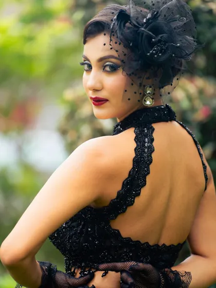 This shot captures the entire vibe of the look, from the dramatic makeup to the stylish black outfit and fascinator. It's all about creating a complete, cohesive story.