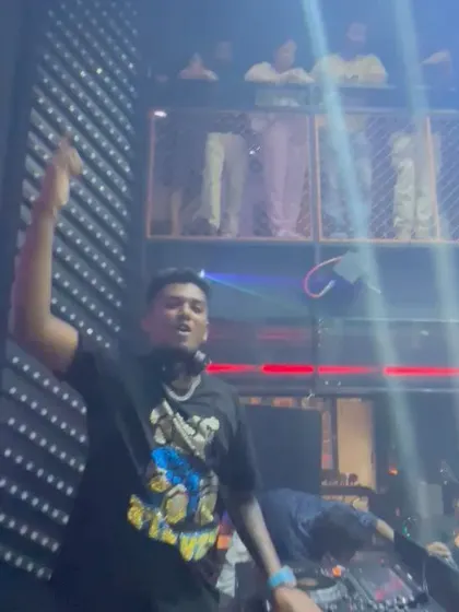 Hyping the crowd from the elevated DJ booth. I make sure to engage with everyone, even those on the upper levels, to create a unified party atmosphere.
