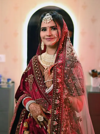 A lovely portrait of the bride in her red velvet wedding lehenga, ready for her big day.