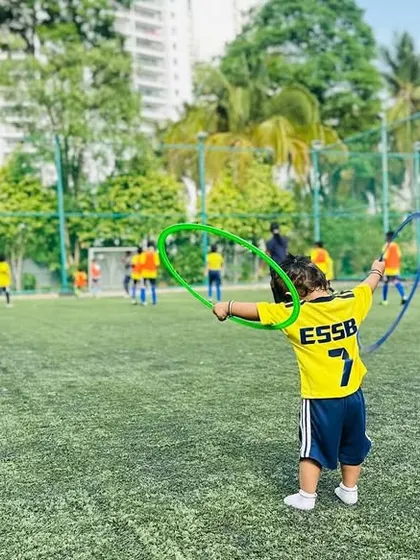 A young player enjoys a game with hoops on a sunny day. We ensure our training grounds are a happy place for kids to be.