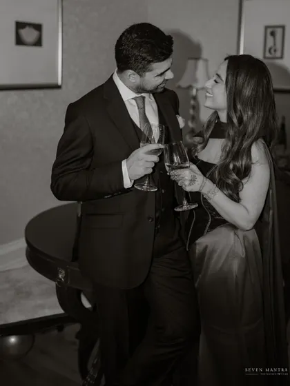 A shared toast, a shared life. This classic, candid shot captures the joy and partnership in a single, elegant frame.