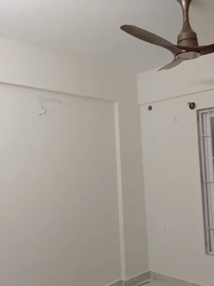 A freshly painted room with clean, off-white walls and a modern ceiling fan. A neutral palette like this offers a timeless and versatile backdrop for any decor.
