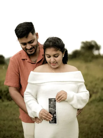 The couple looks down at the sonogram pictures held against the baby bump. It’s a moment of shared wonder and excitement, perfectly captured.