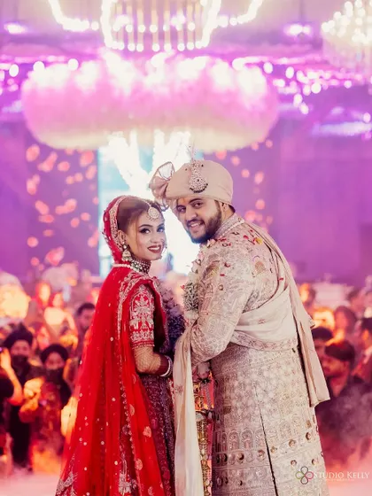 A beautiful shot of the couple at their wedding, surrounded by guests and a dreamy, smoky atmosphere.