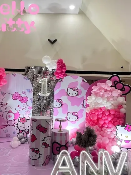 A full view of the Hello Kitty themed birthday decoration. This shows the complete stage with themed backdrops, balloon arrangements, and props creating a perfect photo opportunity.