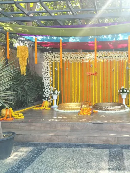 A clear view of the stage for a poolside Haldi function. The setup is clean and traditional, focusing on marigold flowers and urlis, providing a beautiful contrast against the natural surroundings.