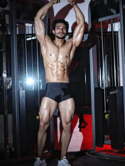 A classic vacuum pose, which requires incredible core control and showcases a small waist and wide lat spread.