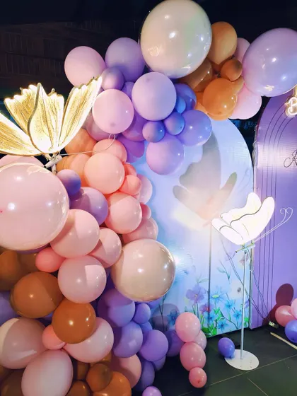 Another detail of the butterfly theme, focusing on the beautiful balloon arrangements and the elegant, lit-up props.