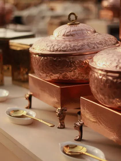Beautifully detailed copper serving dishes, adding a touch of Indian royalty to the buffet.