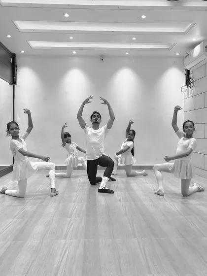 A group of young ballerinas in a synchronized pose with me during a class. These photos show the discipline and coordination we build in our ballet program.
