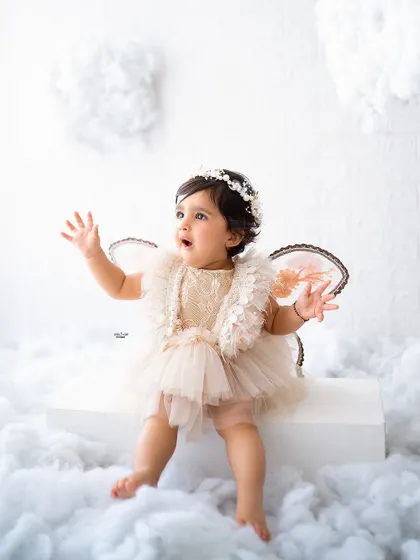 A little angel with her wings, looking up in wonder.
