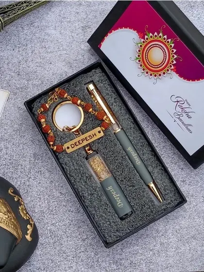 A stylish Rakhi gift set including a personalized rudraksh keychain and a matching pen, presented in a premium box.