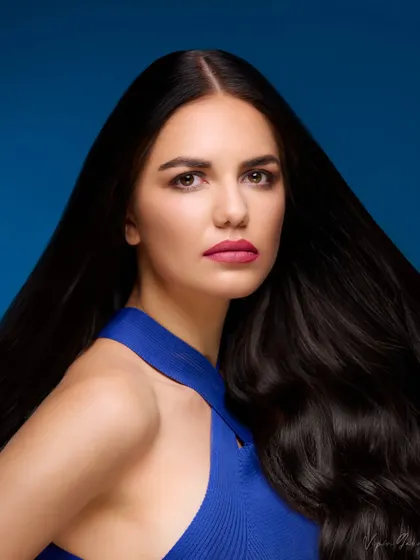 A classic hair-focused beauty shot. The lighting perfectly captures the shine and volume of the model's dark hair, making it ideal for a shampoo or hair care campaign.