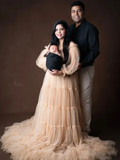 A classic and elegant family portrait with a newborn, showcasing our beautiful client closet gowns.