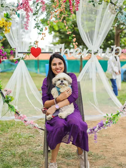 A pet parent posing with her adorable Shih Tzu at our 'I Love Therpup' photo booth during a birthday celebration. It's the perfect spot to capture your memories.