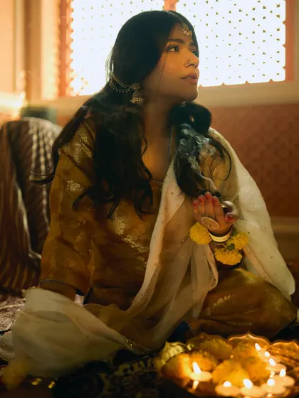 A cinematic shot from a period-themed photoshoot with Sakshi Gopal. The makeup is subtle and evocative, designed to look authentic for a historical setting.