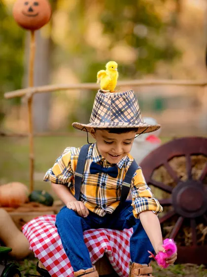 A slightly different angle of this adorable farm-themed shoot. The rustic props and natural setting create a charming and timeless portrait.