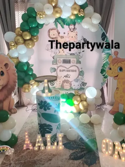 A cozy jungle theme setup for a first birthday at home, featuring a lion and giraffe.
