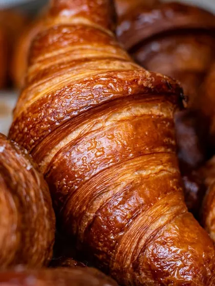 A macro shot focusing on the flaky layers of a croissant. This level of detail communicates quality and freshness to a potential customer.